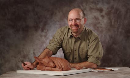 Roger Smith posing with a clay model of a fawn.